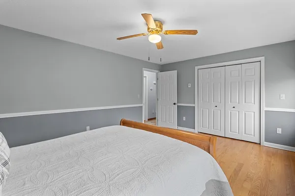 a view of kitchen and empty room with wooden floor