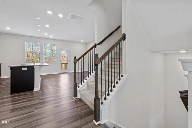 a view of a hallway with wooden floor and staircase