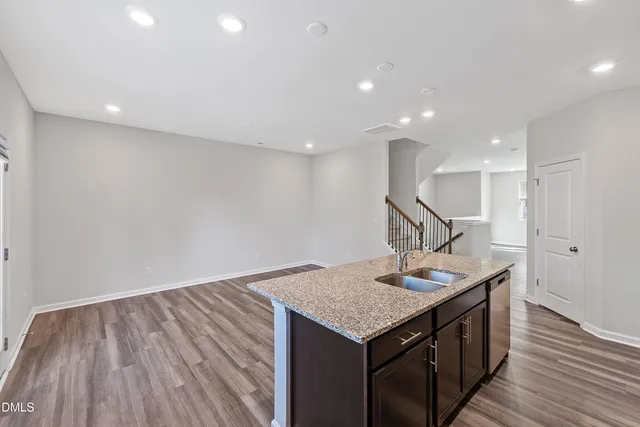 a kitchen with a sink and wooden floor