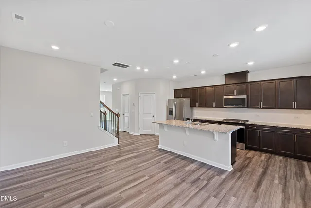 a large kitchen with stainless steel appliances a large counter top and a stove