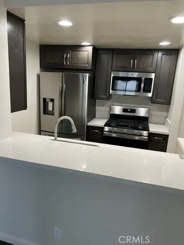 a kitchen with stainless steel appliances a refrigerator sink and microwave