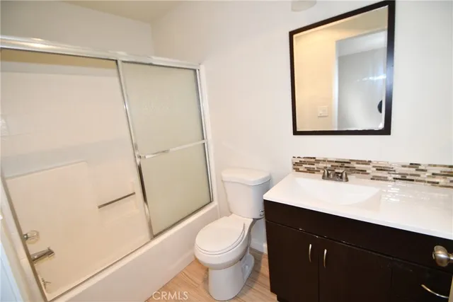 a bathroom with a sink a toilet a mirror and shower