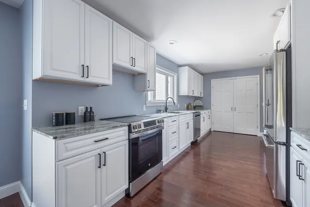 a kitchen with granite countertop white cabinets and white appliances
