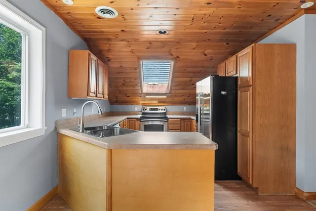 a kitchen with stainless steel appliances granite countertop a sink a refrigerator and a stove