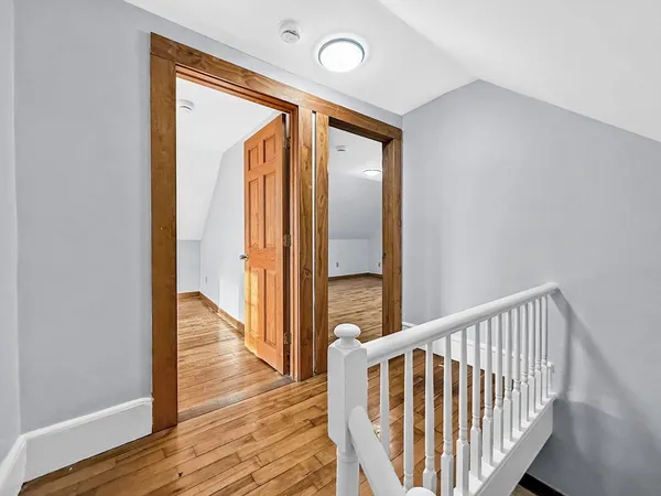 a view of a hallway with wooden floor and staircase