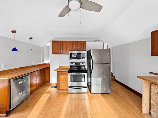 a kitchen with stainless steel appliances granite countertop a refrigerator a stove and a sink