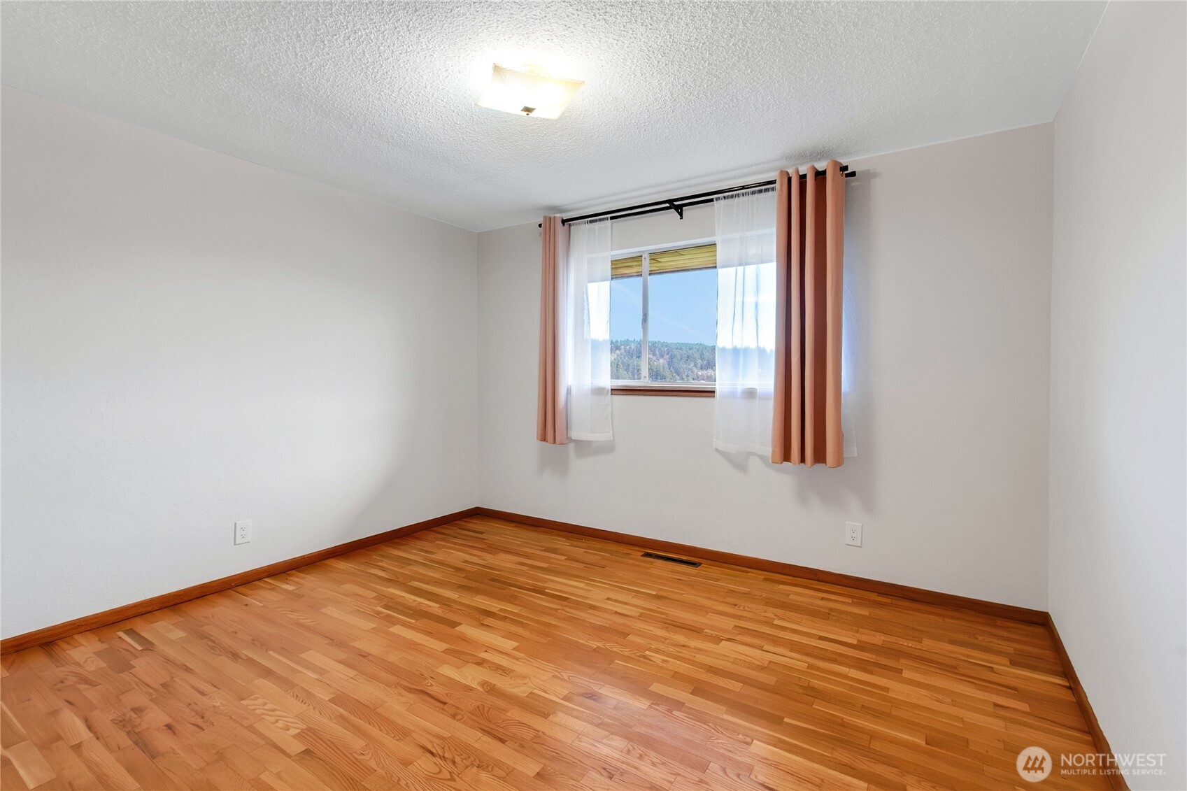 9013 Prentice Avenue Gig Harbor, WA 98332 - Photo 11 of 16 an empty room with wooden floor and windows