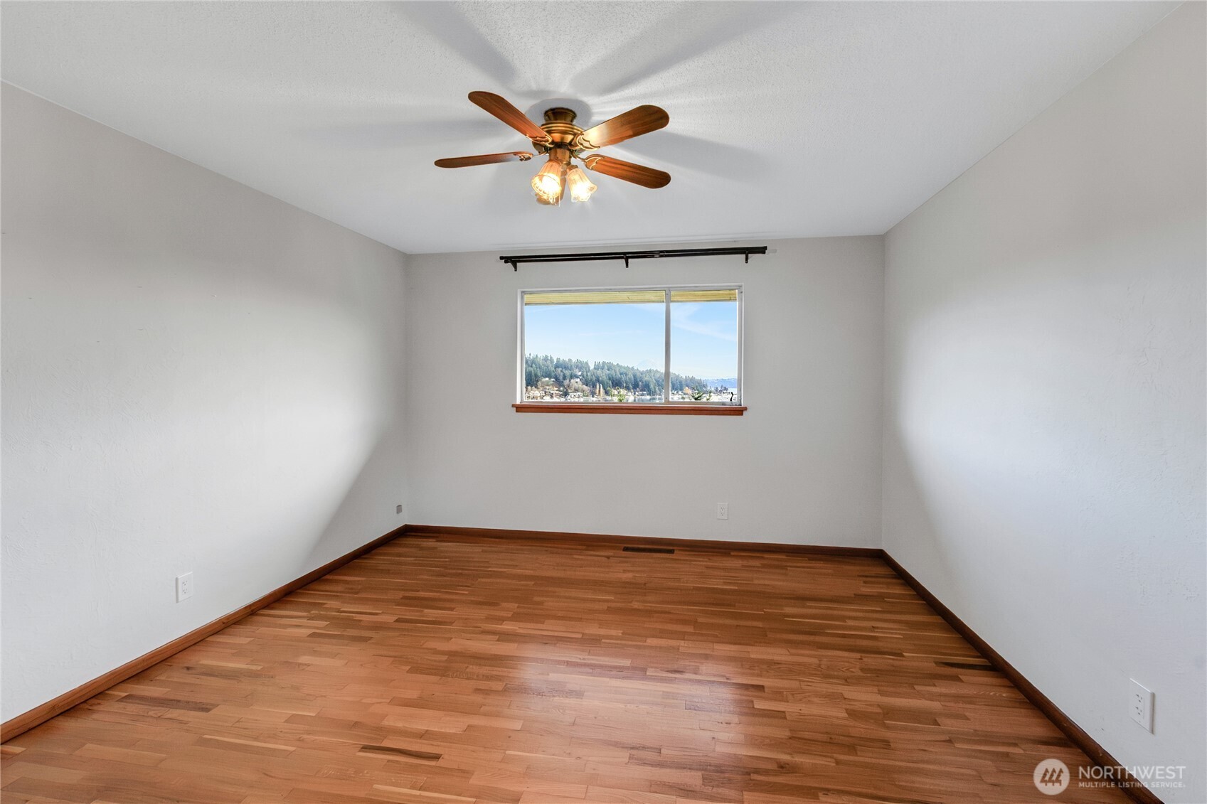9013 Prentice Avenue Gig Harbor, WA 98332 - Photo 12 of 16 a view of an empty room with wooden floor and a window