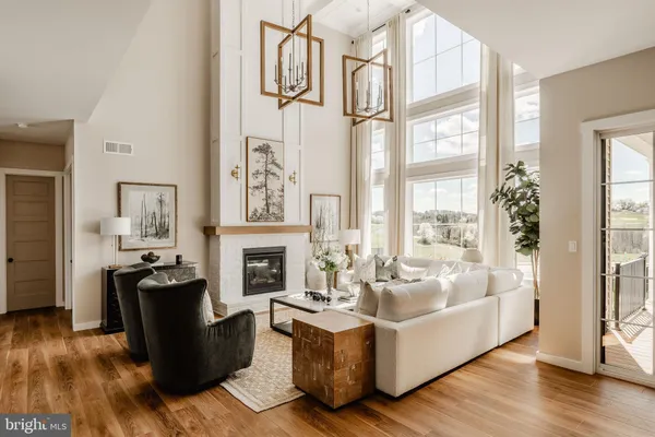 a living room with fireplace furniture and a large window