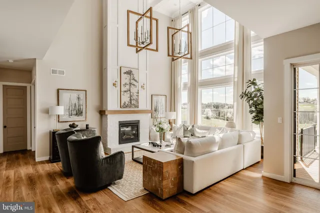 a living room with fireplace furniture and a large window
