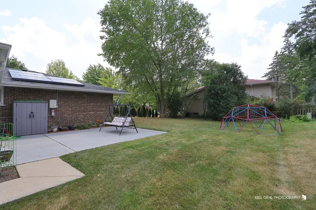 a view of a backyard with table and chairs and a slide