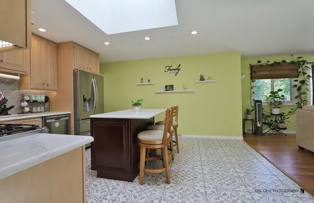 a kitchen with a wooden cabinets and chairs