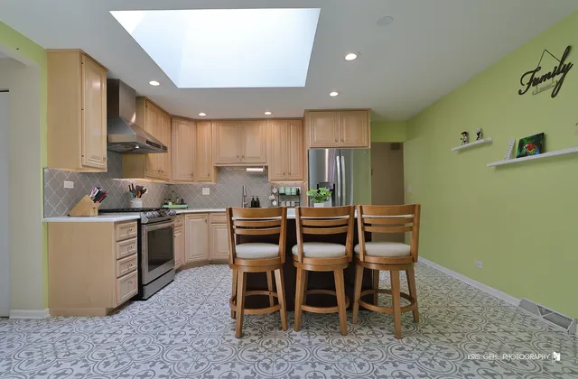 a kitchen with a dining table chairs and white cabinets
