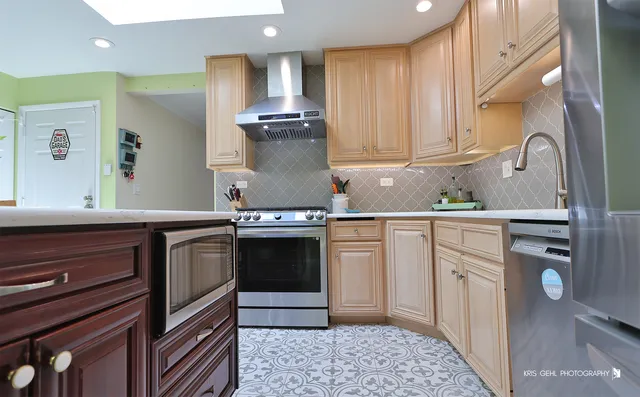 a kitchen with stainless steel appliances granite countertop a sink stove and cabinets