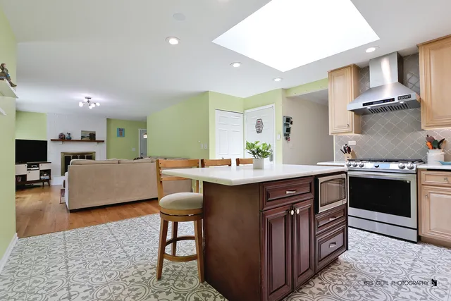 a kitchen with a sink and a stove top oven with wooden floor