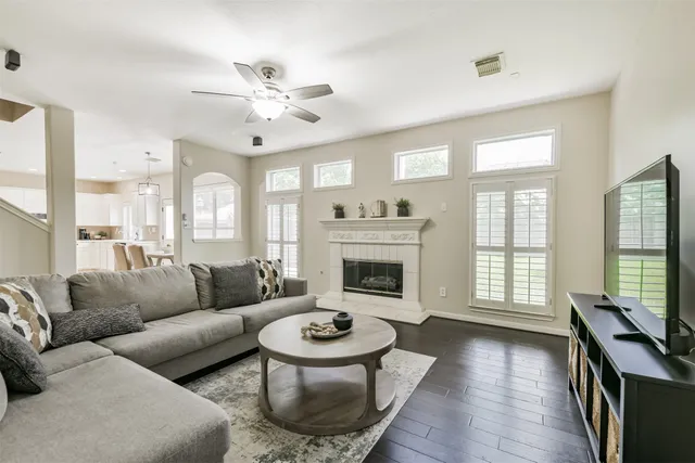 a living room with furniture a fireplace and wooden floor
