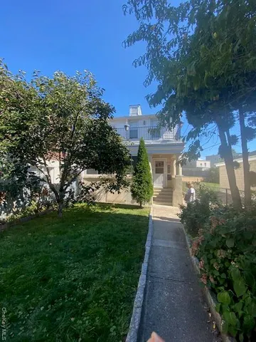 a view of a patio with a table and chairs and a large tree