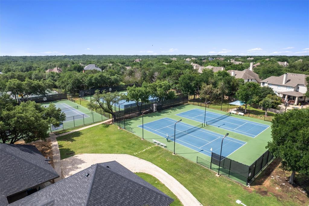 30107 Hamlet Circle Georgetown, TX 78628 - Photo 37 of 40 Four tennis courts with clear blue markings invite active play amidst a verdant landscape.
