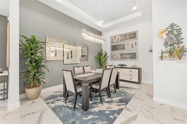 a kitchen with stainless steel appliances kitchen island granite countertop a table chairs and a refrigerator