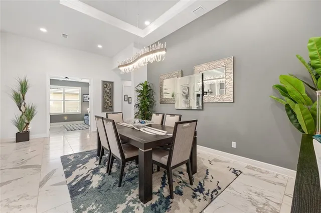 a dining room with furniture a chandelier and glass door