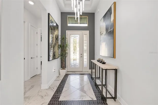 a living room with furniture a flat screen tv and a chandelier
