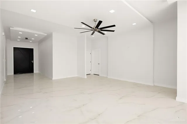 an empty room with closet and a ceiling fan