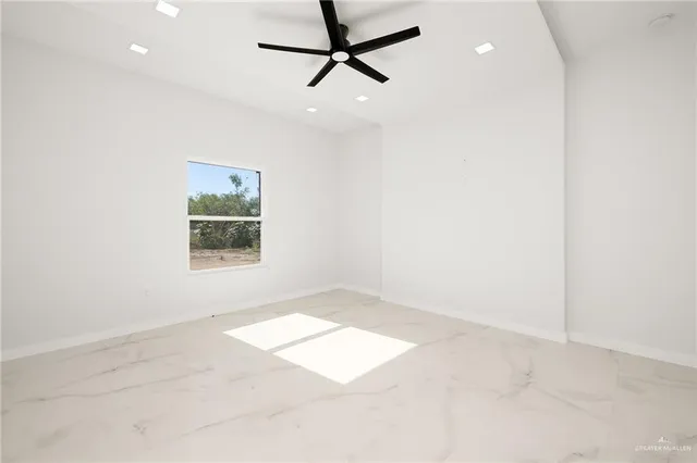 an empty room with windows and fan