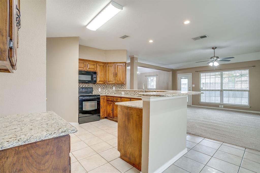 177 Aspen Loop Aledo, TX 76008 - Photo 8 of 40 a kitchen with stainless steel appliances granite countertop a refrigerator and a sink