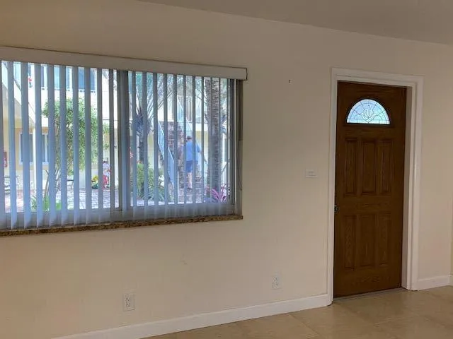 an empty room with a window and a fan