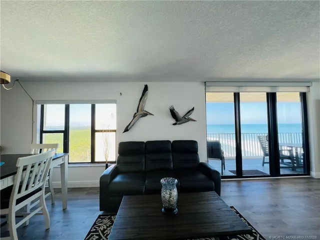 a living room with furniture and a flat screen tv with kitchen view