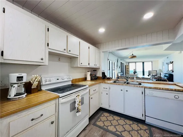 a kitchen with sink a refrigerator and cabinets