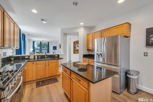 a kitchen with granite countertop a sink refrigerator and microwave