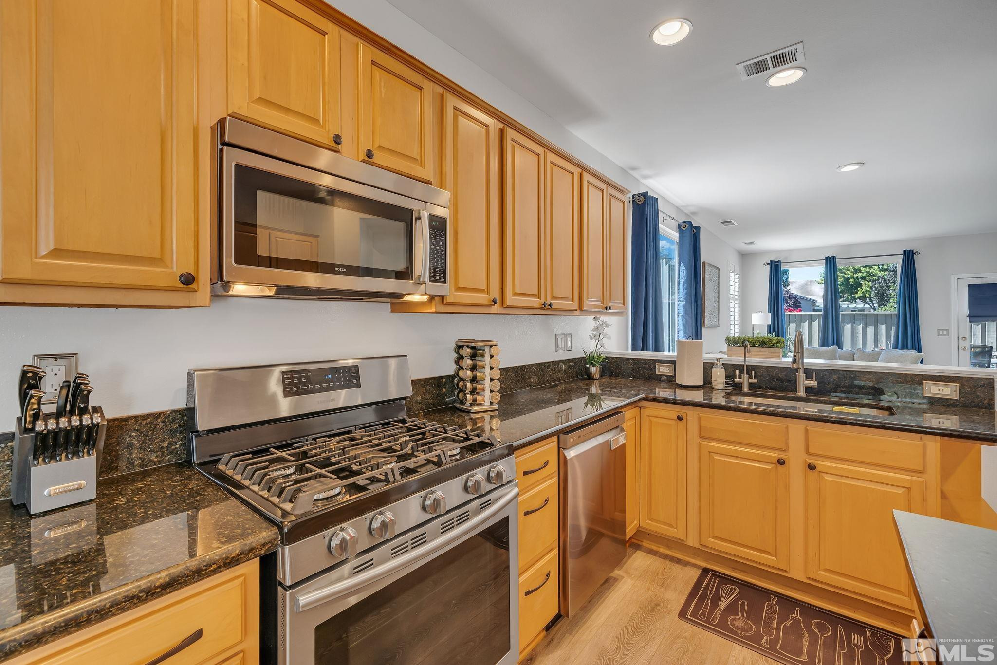 10459 Summershade Lane Reno, NV 89521 - Photo 15 of 37 a kitchen with stainless steel appliances granite countertop a stove a sink and a microwave