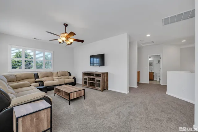 a living room with furniture ceiling fan and a window