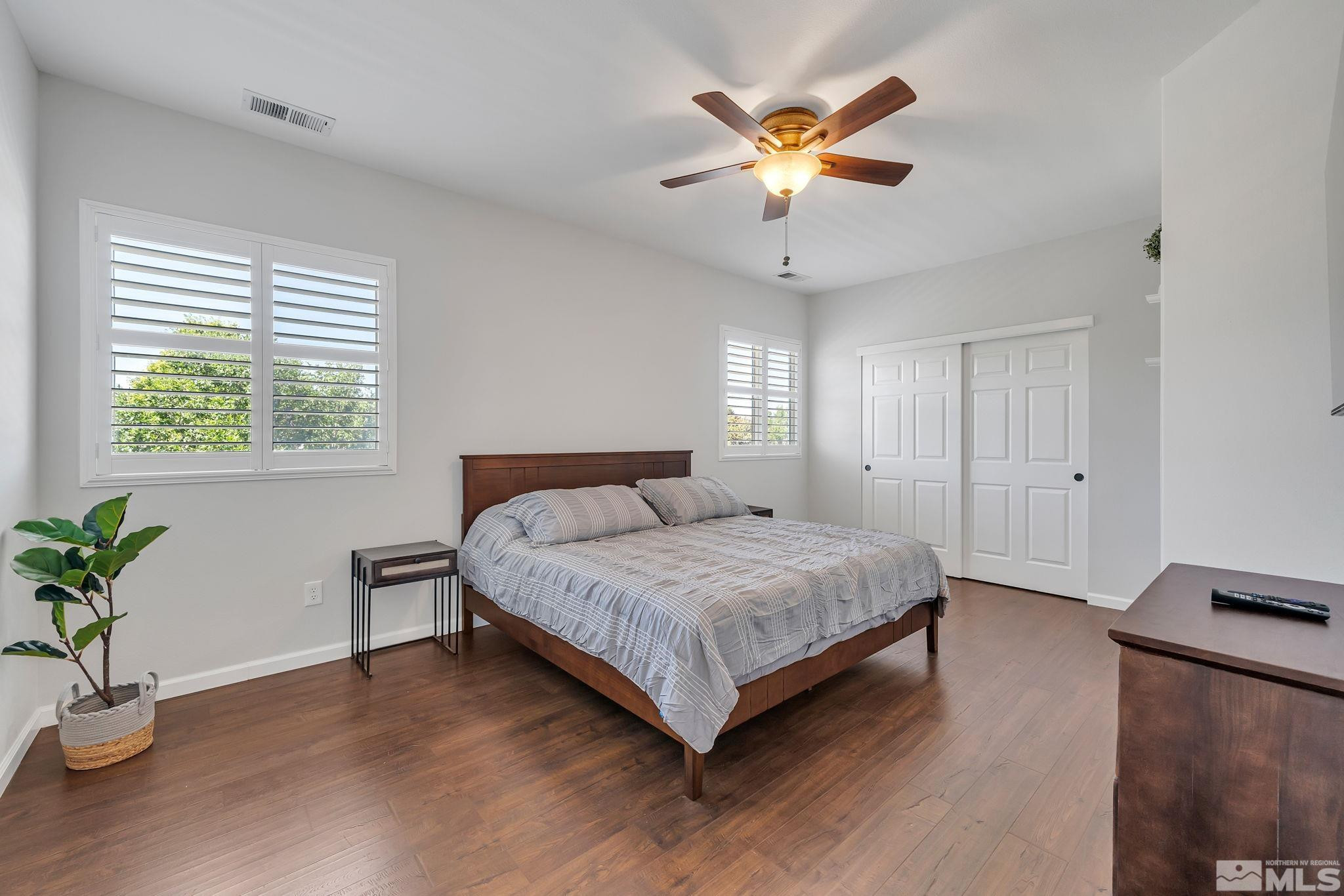 10459 Summershade Lane Reno, NV 89521 - Photo 26 of 37 a bedroom with a large bed chandelier and a window