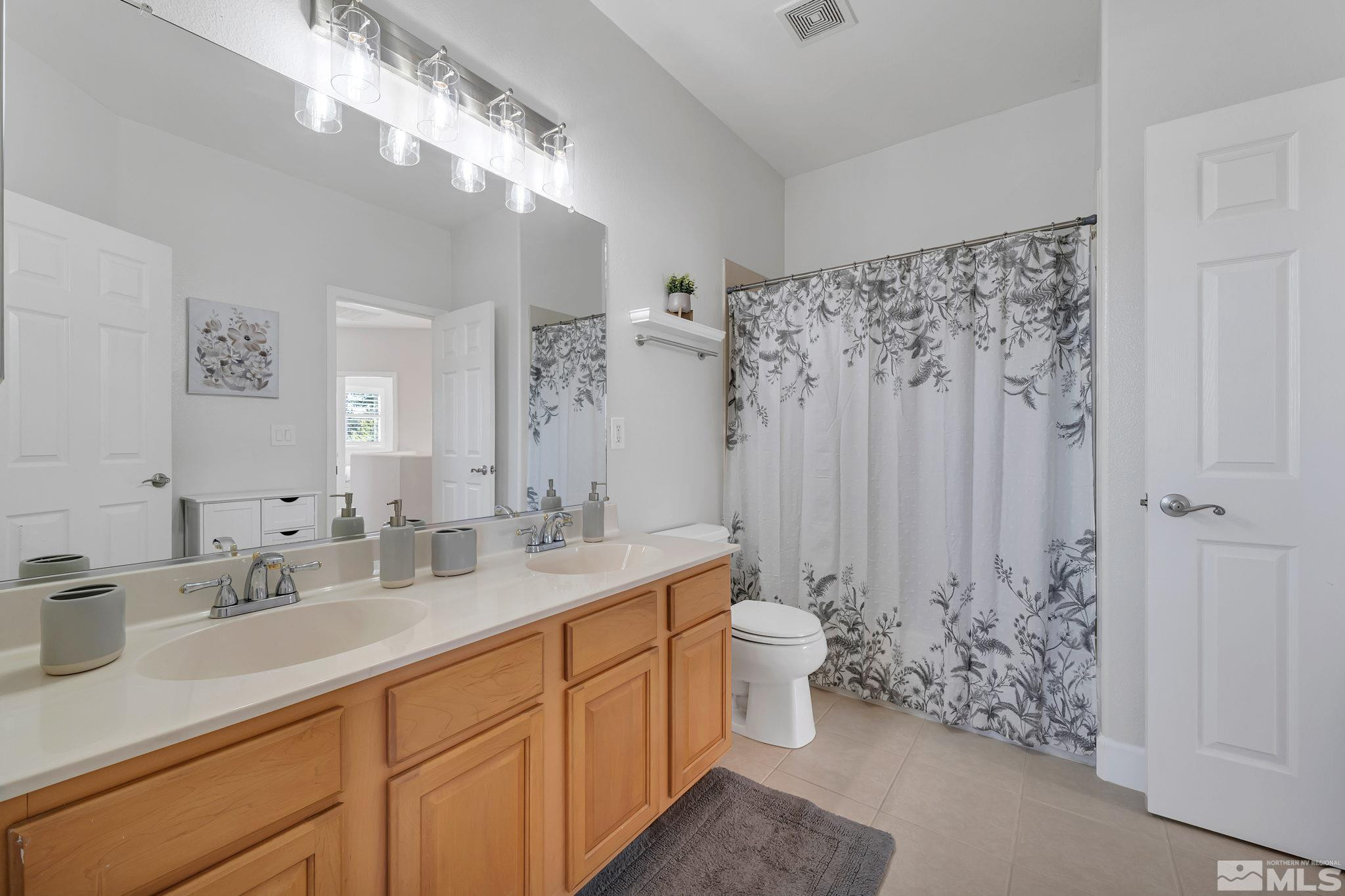 10459 Summershade Lane Reno, NV 89521 - Photo 28 of 37 a spacious bathroom with a double vanity sink toilet and a mirror