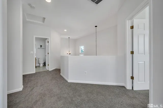 a view of an empty room and kitchen view