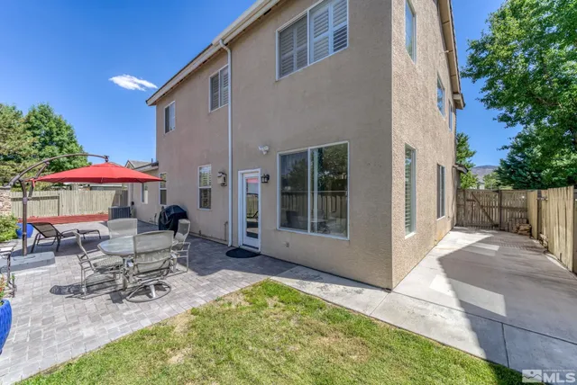 a backyard of a house with table and chairs