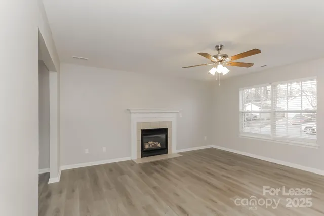 an empty room with windows and fireplace