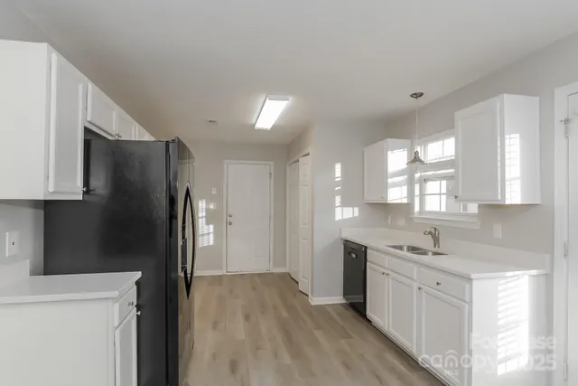a kitchen with a refrigerator sink and cabinets