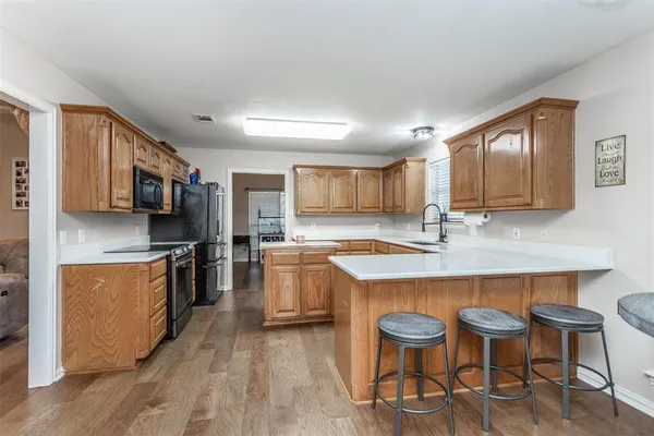 a kitchen with stainless steel appliances granite countertop a kitchen island hardwood floor sink and stove