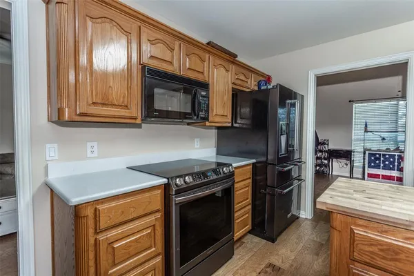 a kitchen with stainless steel appliances granite countertop a stove microwave refrigerator and sink