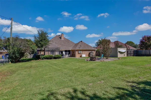 a view of a big house with a big yard and large tree
