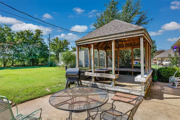 a patio with a yard table and chairs