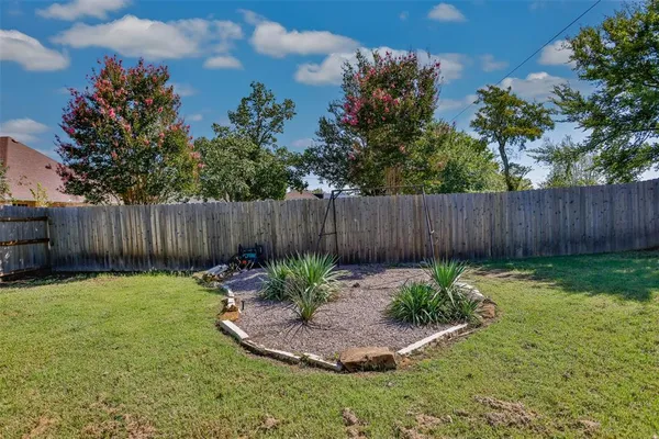 a view of garden with wooden fence