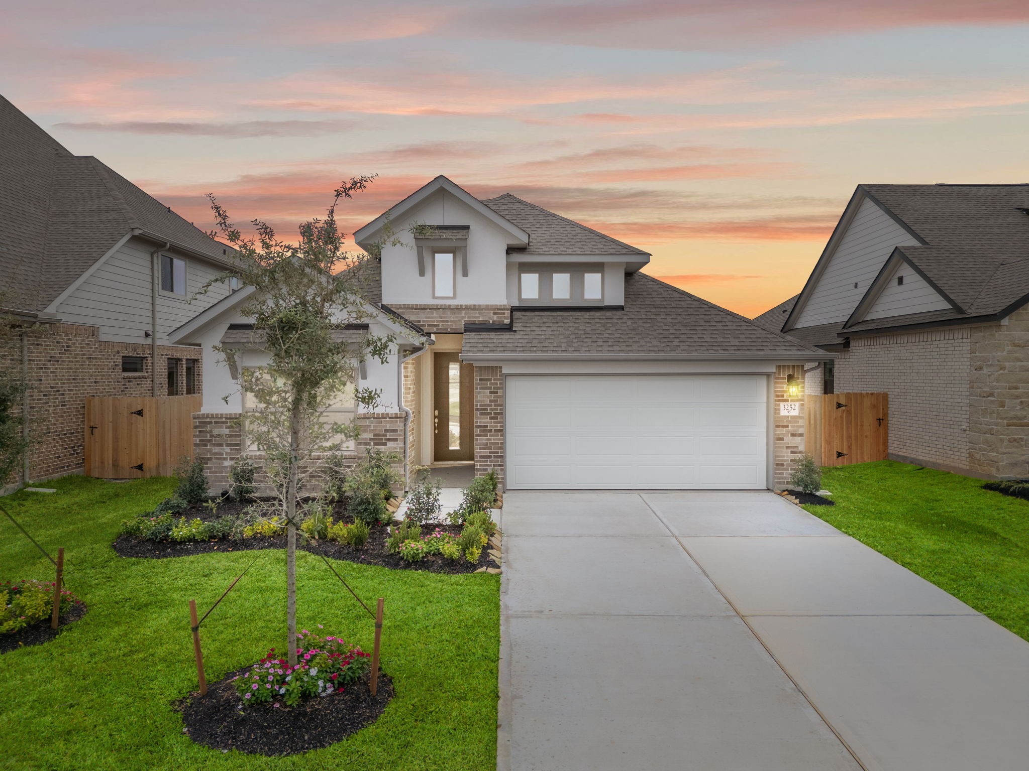 a front view of a house with a garden and yard