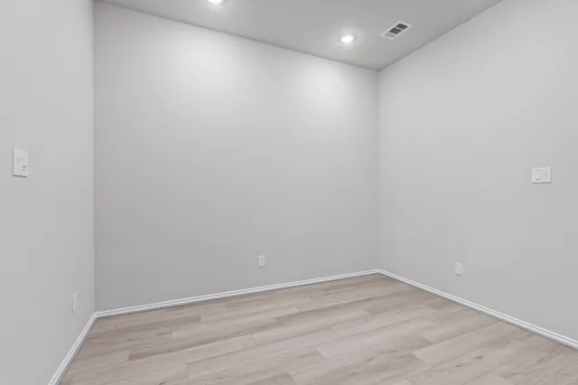 an empty room with a chandelier fan