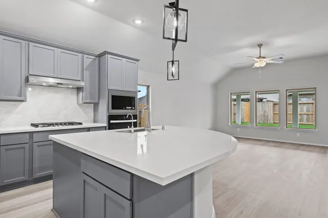 a kitchen with a stove a sink and a refrigerator