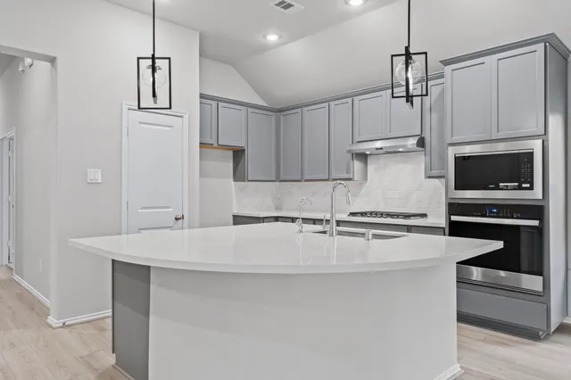 a kitchen with kitchen island a stove a sink and a refrigerator