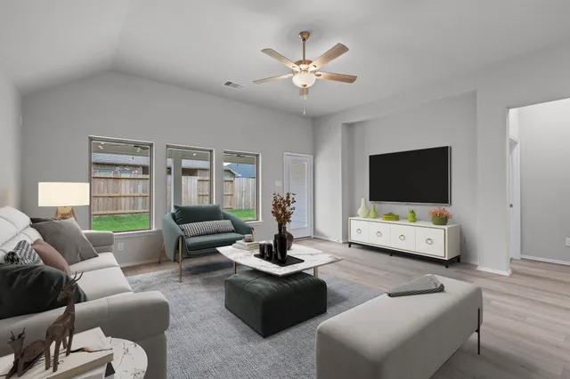 a spacious bedroom with a bed a couch and potted plant